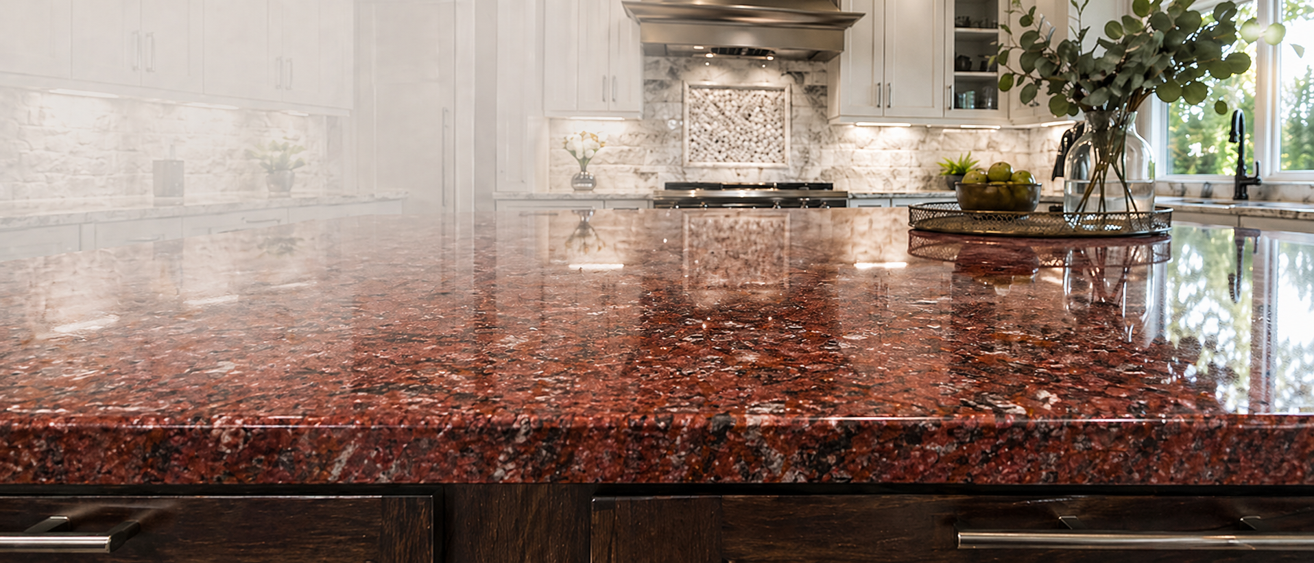 Polished Red Multi granite kitchen island with white cabinetry and natural light